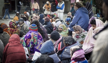 A group of homeless people at a drop-in centre in Delhi being given food, advice and help.